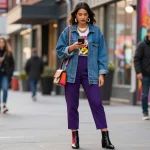 Confident woman showcasing trending women's fashion in urban street style with accessories.